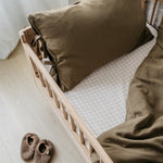 A toddler bed made from European oak with protective railings on all around, featuring a natural wood finish. Available in Singapore.
