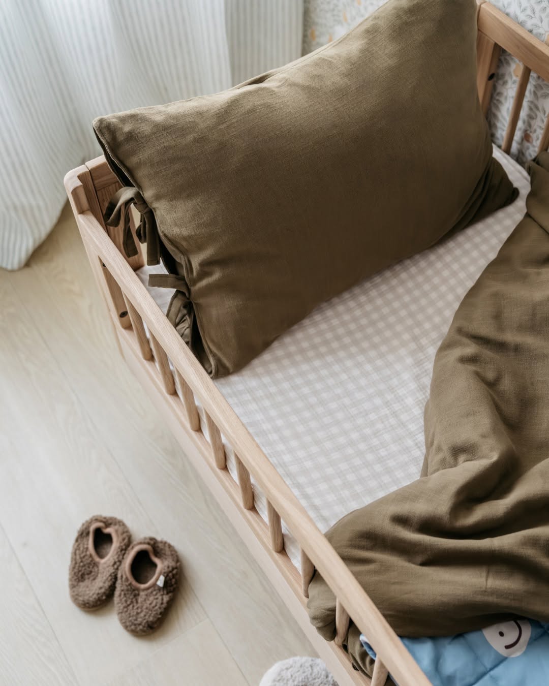 A toddler bed made from European oak with protective railings on all around, featuring a natural wood finish. Available in Singapore.