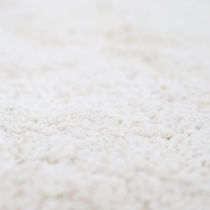 A round beige cotton rug with a lace finish, kids rugs and carpets singapore