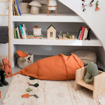 A large, orange, carrot-shaped bean bag with a green leaf on top, made of cotton fabric, kids bean bags and poufs singapore