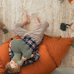 A large, orange, carrot-shaped bean bag with a green leaf on top, made of cotton fabric, kids bean bags and poufs singapore