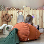 A large, orange, carrot-shaped bean bag with a green leaf on top, made of cotton fabric, kids bean bags and poufs singapore