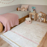 A rectangular, flatweave washable rug in beige, pink, and gray tones with a minimalistic geometric pattern, kids rugs and carpets singapore