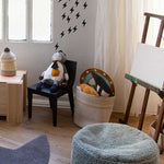 A round vintage blue pouf made of cotton, with a textured surface and a visible carrying handle, kids bean bags and poufs in Singapore