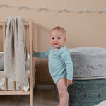 A round vintage blue pouf made of cotton, with a textured surface and a visible carrying handle, kids bean bags and poufs in Singapore