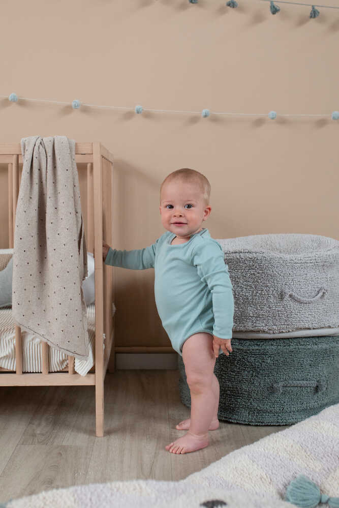 A round vintage blue pouf made of cotton, with a textured surface and a visible carrying handle, kids bean bags and poufs in Singapore