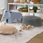 A round vintage blue pouf made of cotton, with a textured surface and a visible carrying handle, kids bean bags and poufs in Singapore