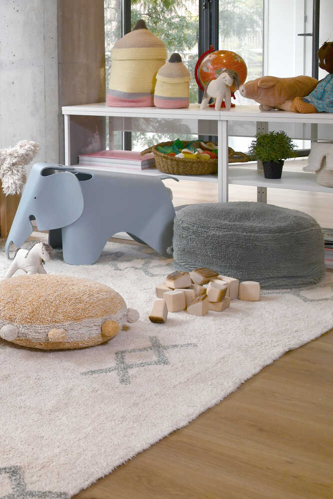 A round vintage blue pouf made of cotton, with a textured surface and a visible carrying handle, kids bean bags and poufs in Singapore