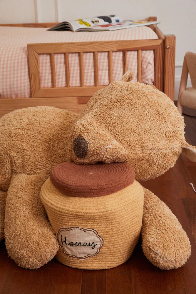 A plush toy resembling a sleepy bear with soft fur in honey-coloured tones, featuring a zipper on its bottom for removing the inner filler, kids bean bags and poufs Singapore, lorena canals singapore