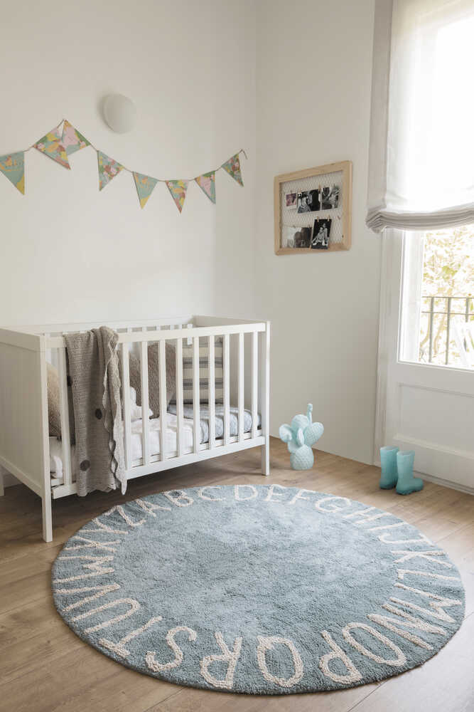 A round blue rug with the letters of the alphabet in white arranged around the edge. kids rugs singapore