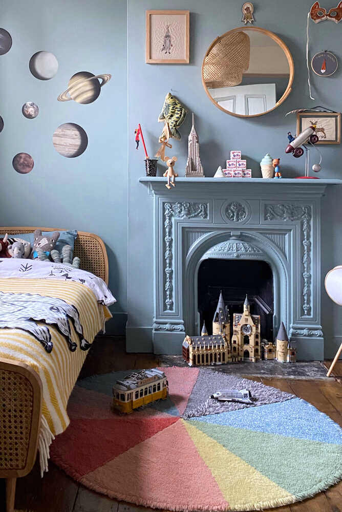A round wool rug with a colorful pie chart design, featuring shades of green, blue, red, and gray, rainbow rug, kids rugs and carpets Singapore