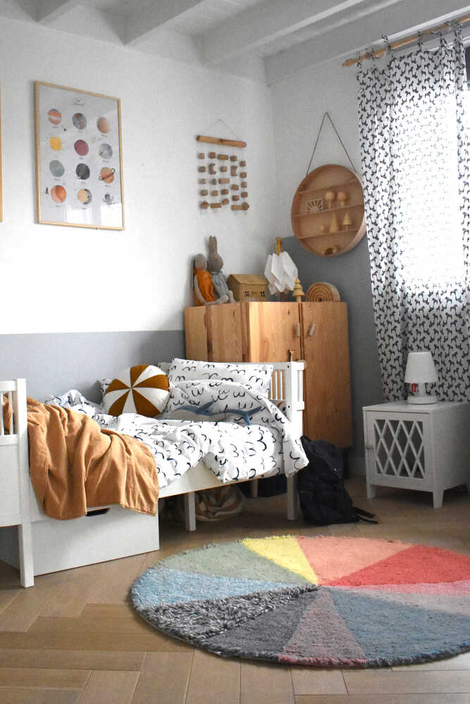 A round wool rug with a colorful pie chart design, featuring shades of green, blue, red, and gray, rainbow rug, kids rugs and carpets Singapore