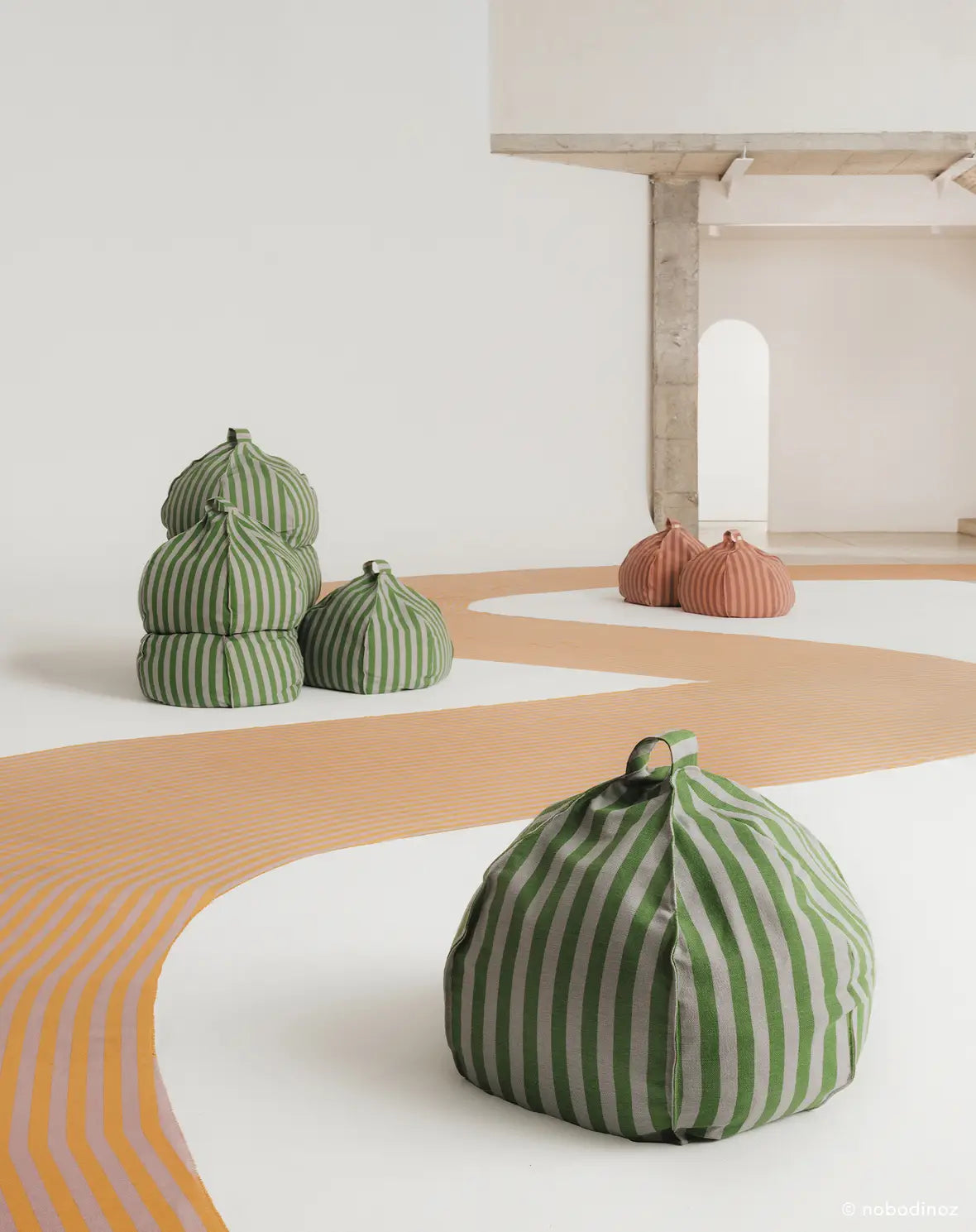 A round bean bag chair with pink and mauve vertical stripes, featuring a handle at the top for easy movement, kids bean bags and poufs in Singapore