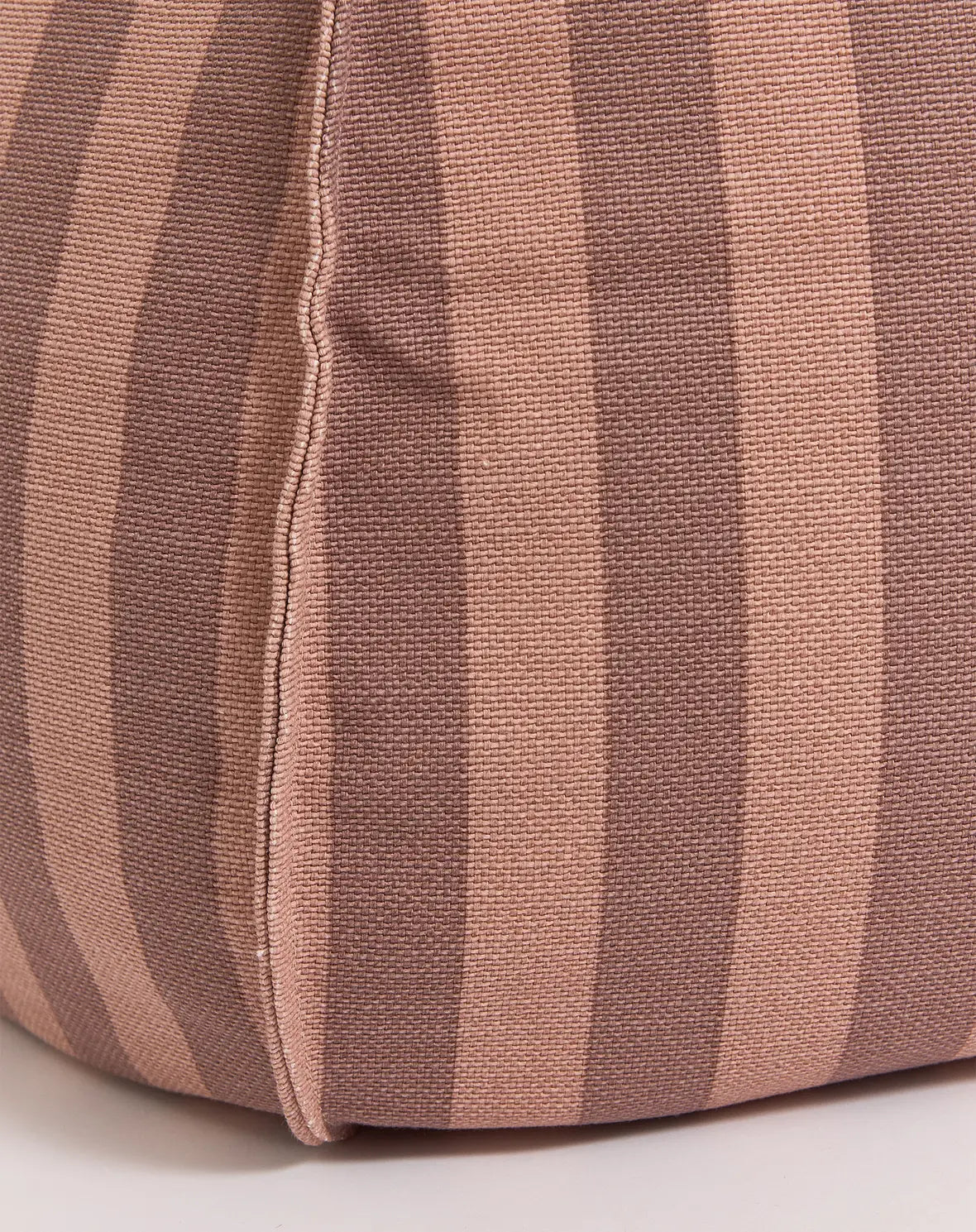 A round bean bag chair with pink and mauve vertical stripes, featuring a handle at the top for easy movement, kids bean bags and poufs in Singapore