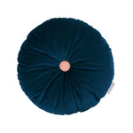 A round, night blue cushion with a contrasting pink button in the center, made from eco-velvet fabric, available in Singapore