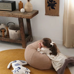A round quilted beanbag chair in a beige color with a textured pattern, featuring a handle, kids bean bags and poufs Singapore
