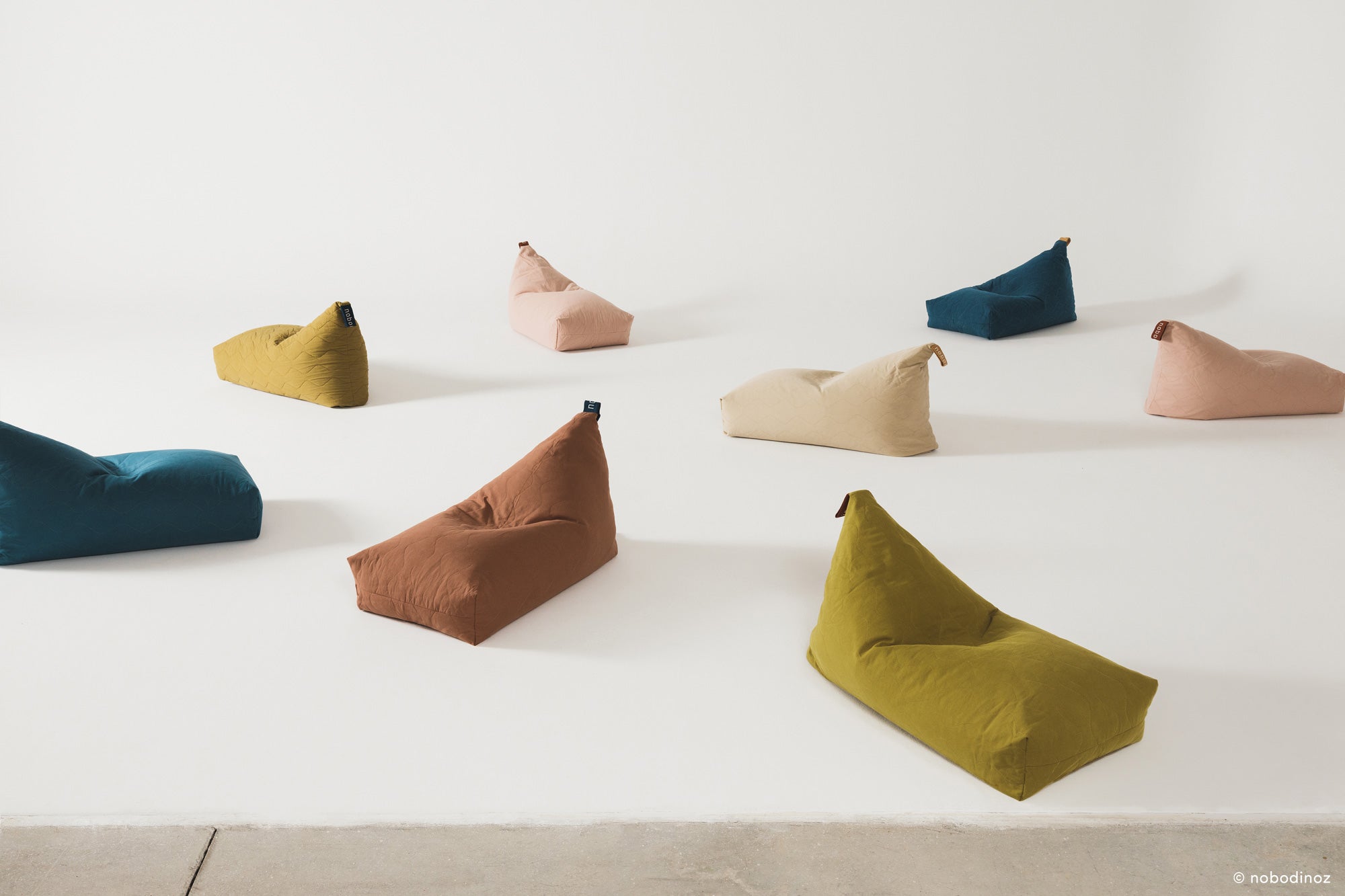 A brown quilted long beanbag with an embroidered handle, placed against a neutral background, kids bean bags and poufs in Singapore