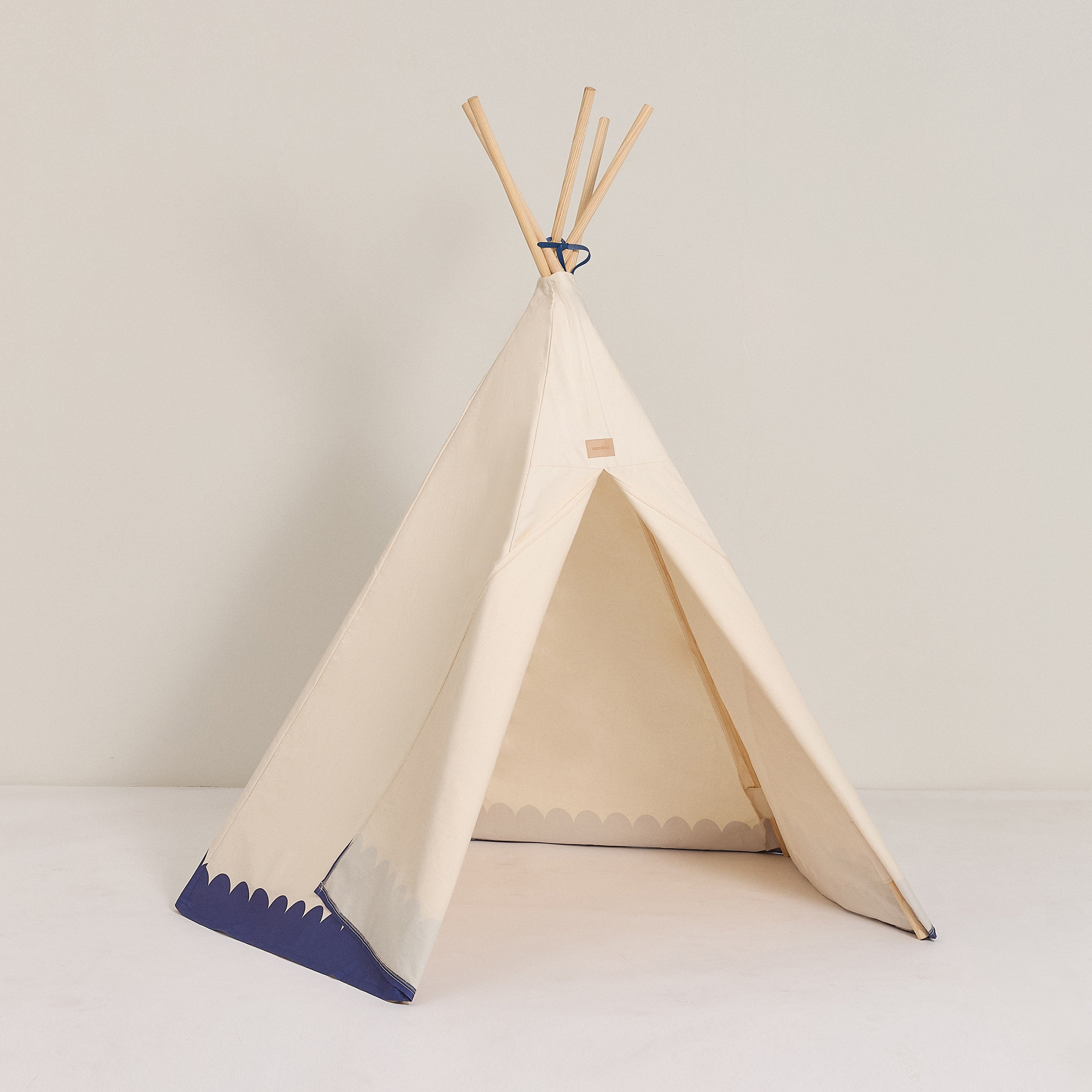 A blue and white Nobodinoz Vibes Tipi Arizona play tent made of organic cotton with wooden sticks, designed for children's indoor play, kids tipi tent, children tipi tent, available in Singapore