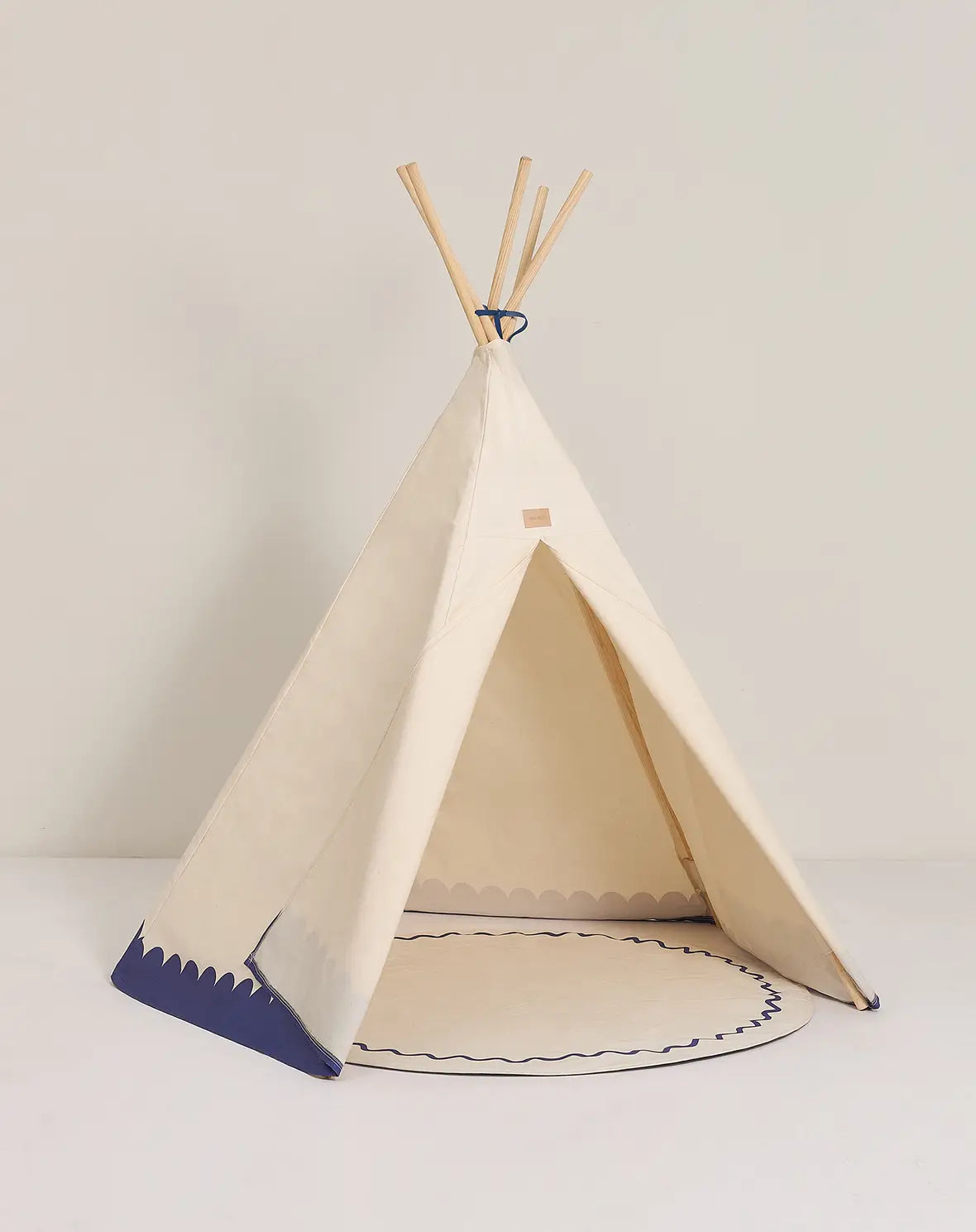 A blue and white Nobodinoz Vibes Tipi Arizona play tent made of organic cotton with wooden sticks, designed for children's indoor play, kids tipi tent, children tipi tent, available in Singapore