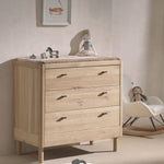 A three-drawer chest made of oak wood, with a natural wood finish and metal handles. available in singapore