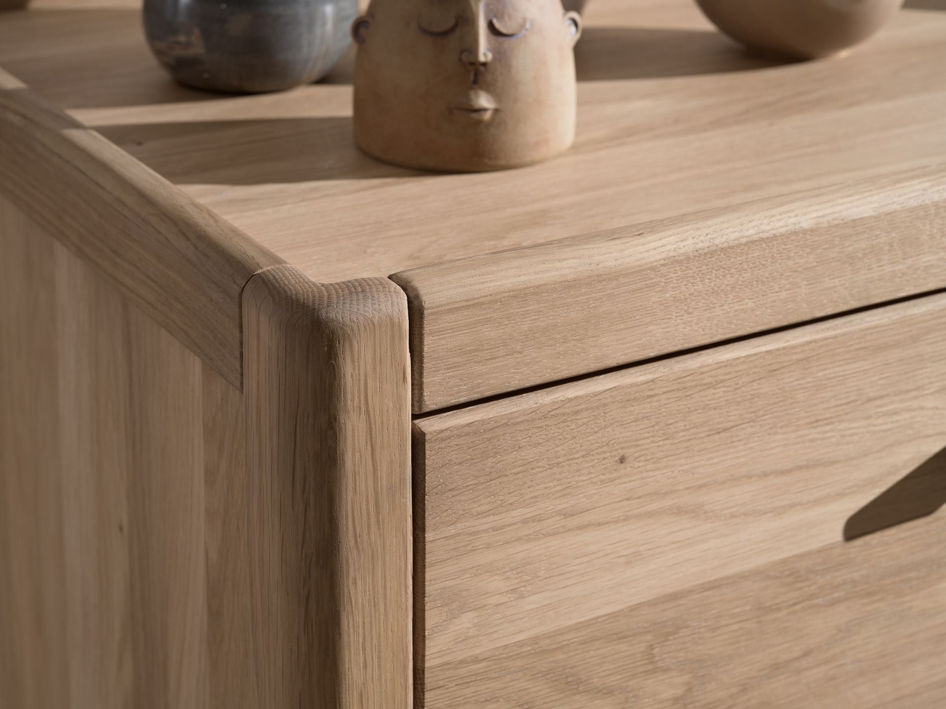 A three-drawer chest made of oak wood, with a natural wood finish and metal handles. available in singapore