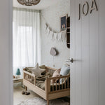 A toddler bed made from European oak with protective railings on all around, featuring a natural wood finish. Available in Singapore.