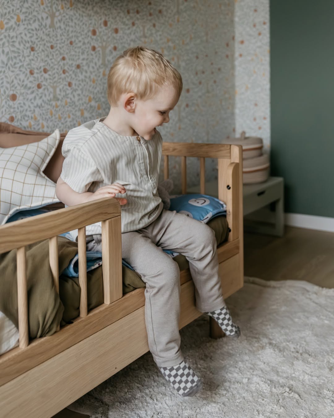 A toddler bed made from European oak with protective railings on all around, featuring a natural wood finish. Available in Singapore.