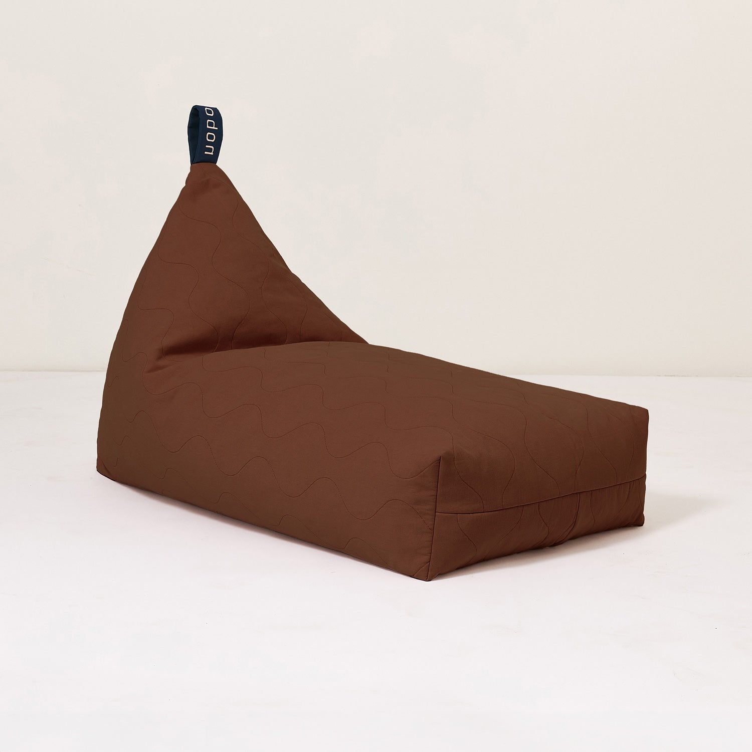 A brown quilted long beanbag with an embroidered handle, placed against a neutral background, kids bean bags and poufs in Singapore