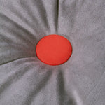 A round cushion with a slate grey color and a central orange button, from the Nobodinoz, Eco-Velvet collection, available in Singapore