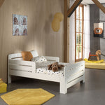 A white transformable bed with a mattress, designed to adjust in length. Available in Singapore, kids bed singapore, kids toddler bed singapore