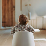 A beige Quax potty with a white inner bowl and high backrest, designed for toddlers.