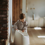 A beige Quax potty with a white inner bowl and high backrest, designed for toddlers.