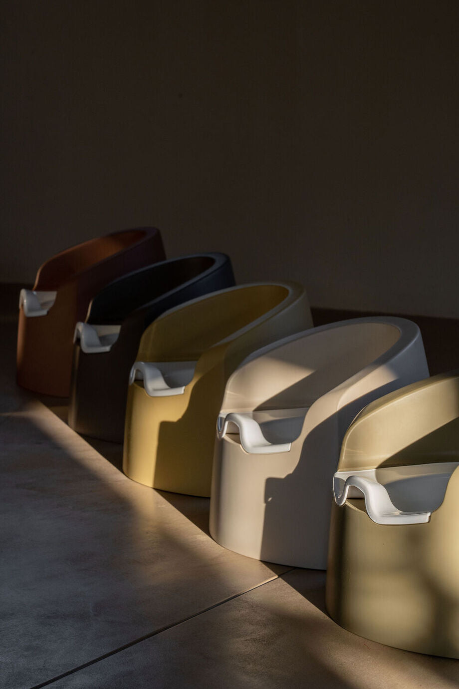 A beige Quax potty with a white inner bowl and high backrest, designed for toddlers.