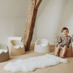 A beige Quax potty with a white inner bowl and high backrest, designed for toddlers.