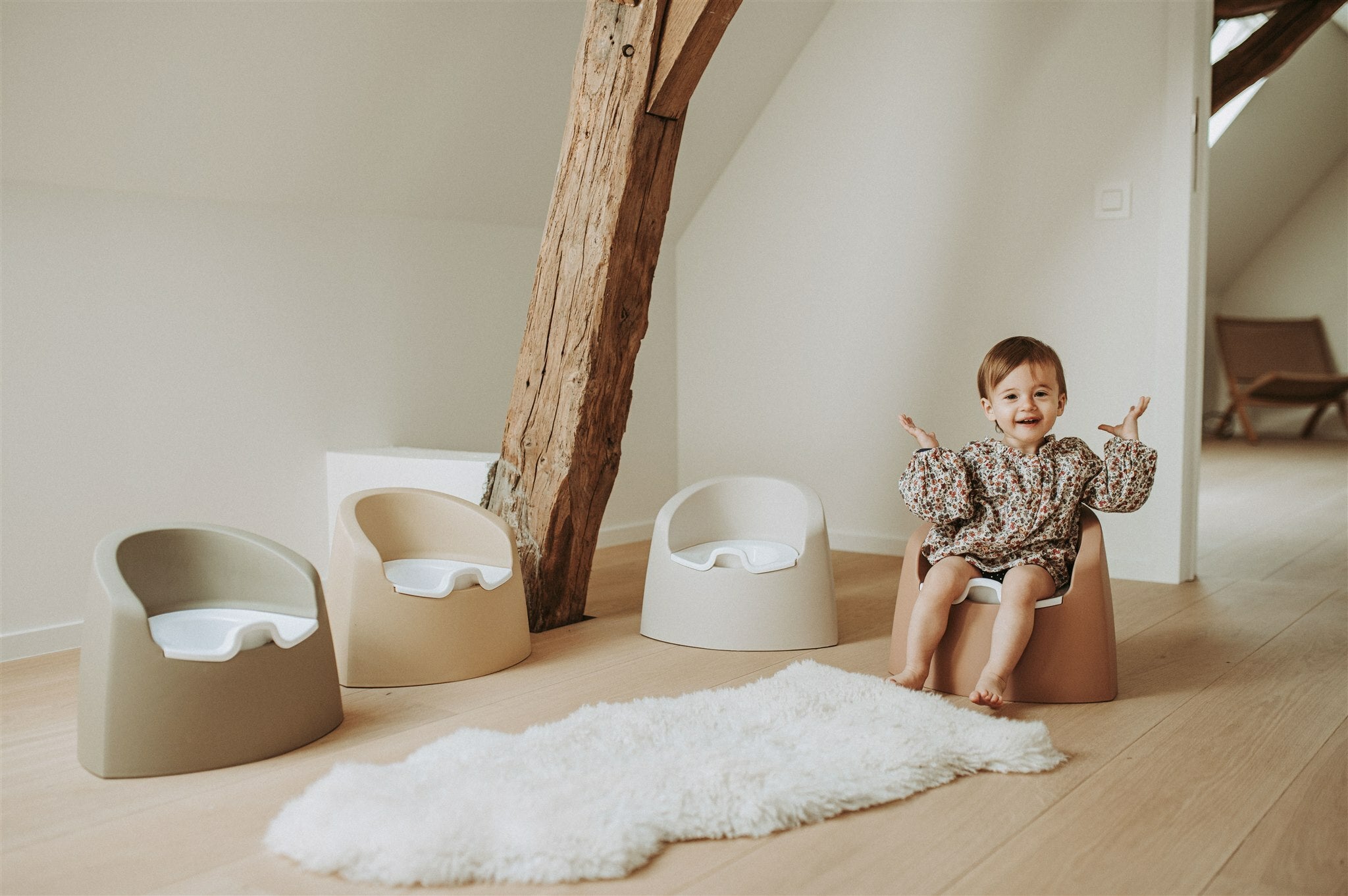A beige Quax potty with a white inner bowl and high backrest, designed for toddlers.