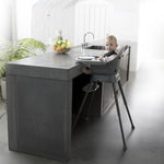 A Quax Ultimo High Chair in stone color with a modern design, featuring a high seat and adjustable legs, suitable for babies and toddlers.